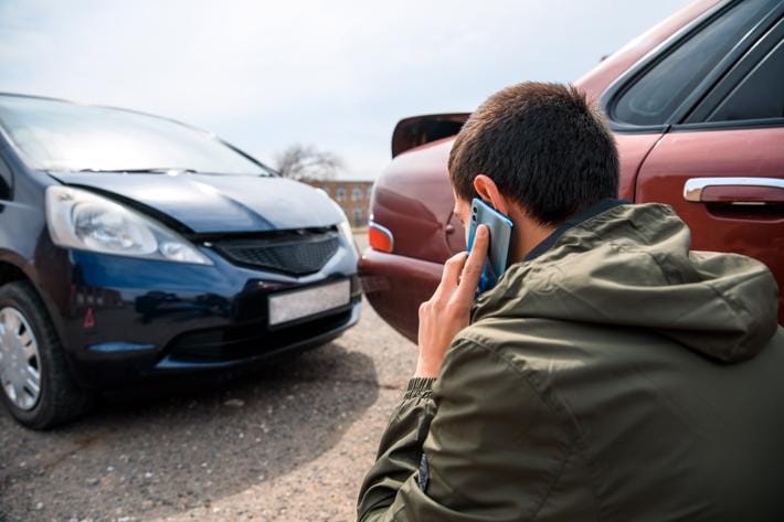 Person talking on a phone after a car accident